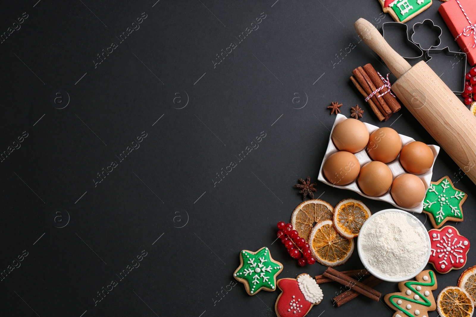 Photo of Flat lay composition with homemade Christmas cookies and ingredients on black background, space for text