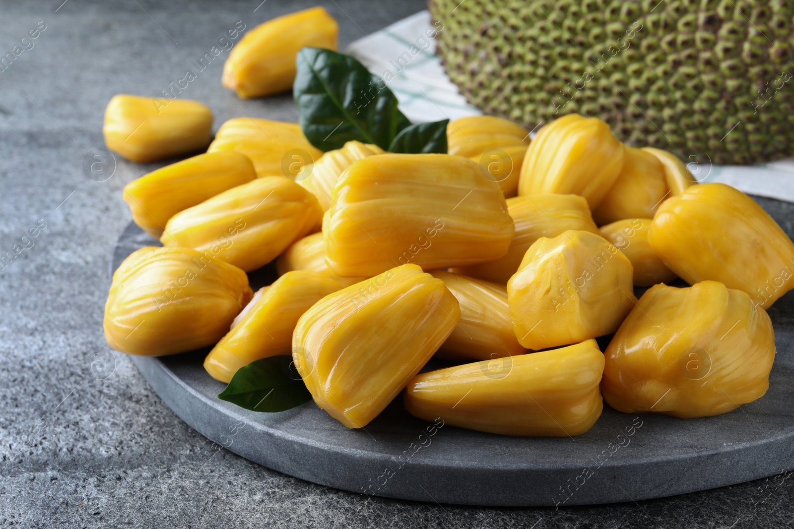 Photo of Fresh exotic jackfruit bulbs on grey table