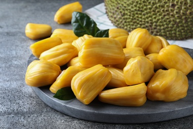 Fresh exotic jackfruit bulbs on grey table