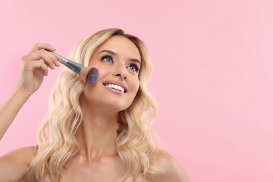 Beautiful makeup. Smiling woman with brush on pink background, space for text