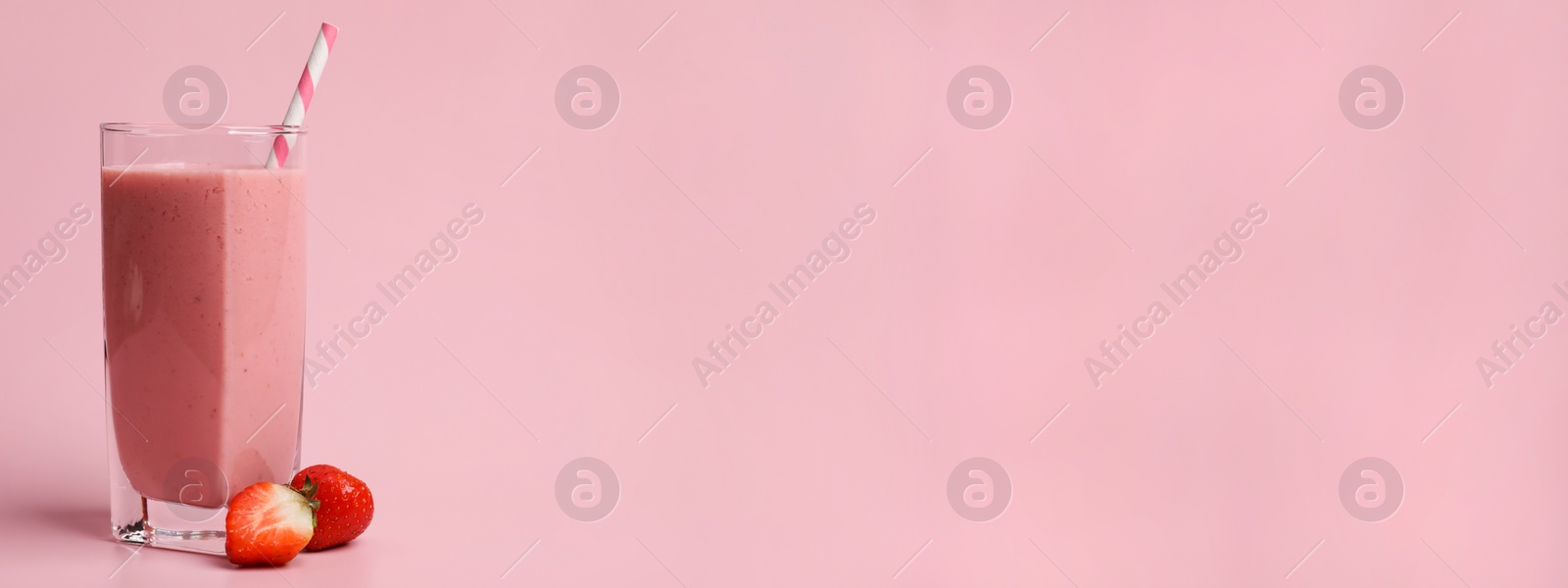 Image of Glass with delicious berry smoothie and fresh strawberries on pink background, space for text. Banner design