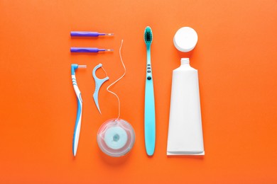 Photo of Flat lay composition with dental floss and different teeth care products on orange background