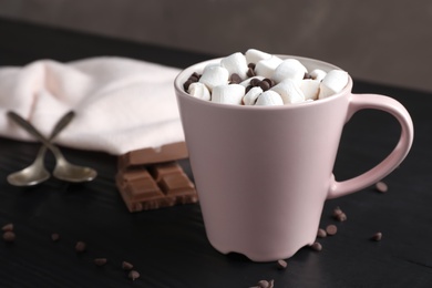 Photo of Tasty hot chocolate with milk and marshmallows in cup on table