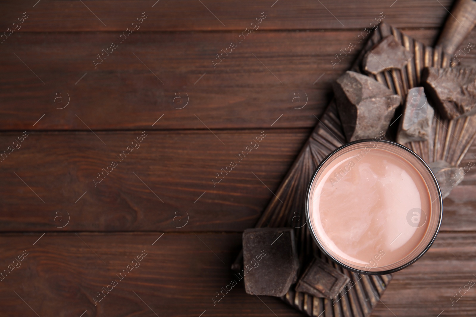 Photo of Fresh yummy chocolate milk on wooden table, top view. Space for text