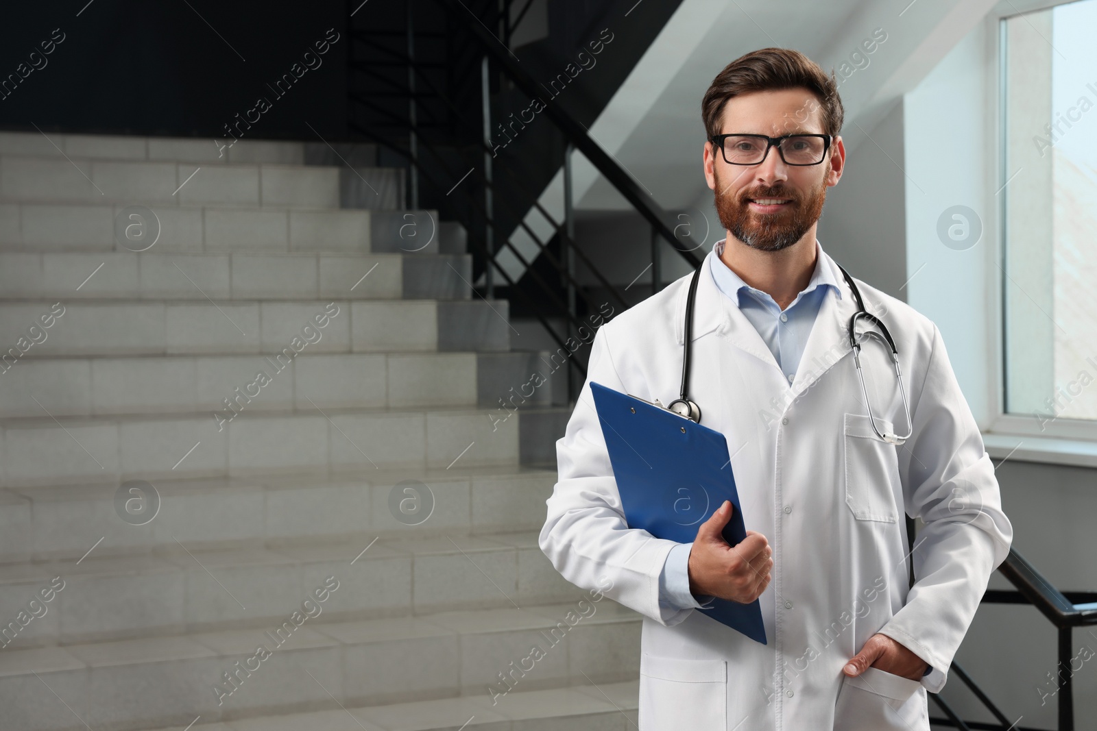 Photo of Doctor with stethoscope and clipboard in hospital. Space for text