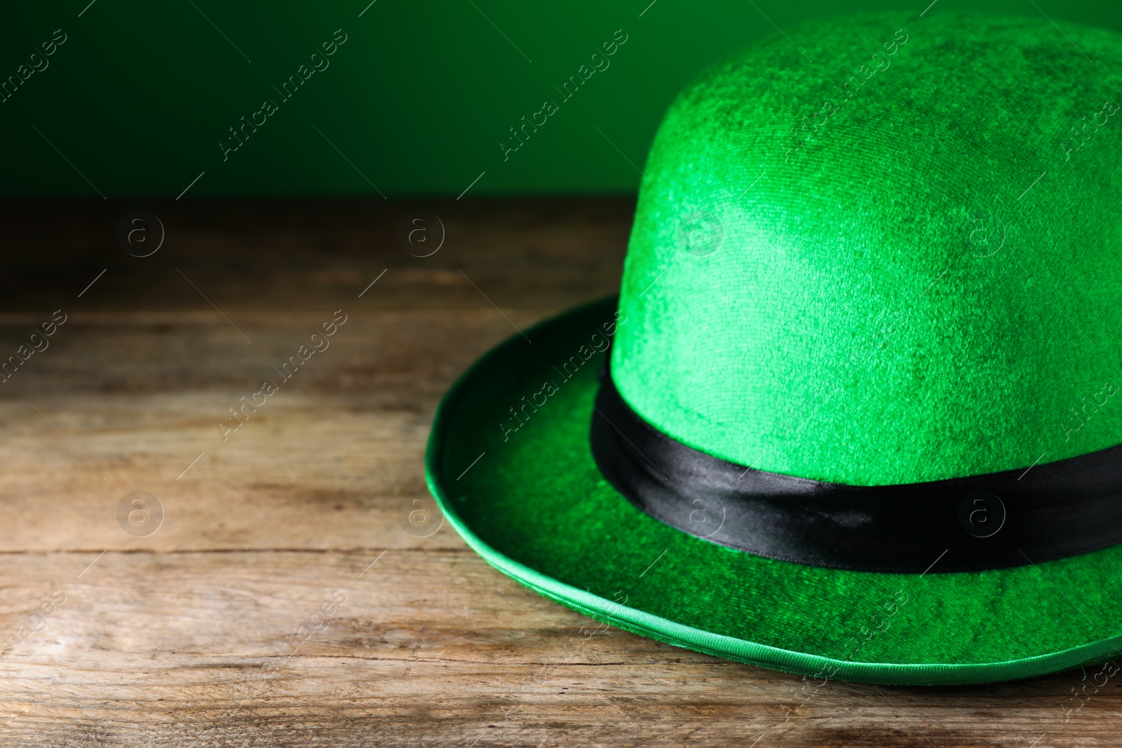 Photo of Green leprechaun hat on wooden table, closeup. St. Patrick's Day celebration