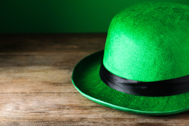 Photo of Green leprechaun hat on wooden table, closeup. St. Patrick's Day celebration