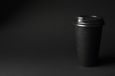 Photo of Takeaway paper coffee cup on dark background, space for text. Black Friday concept