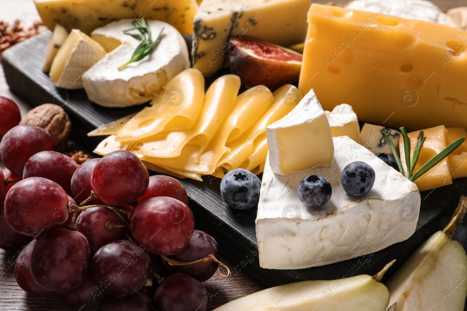 Photo of Composition with different delicious cheeses and fruits, closeup