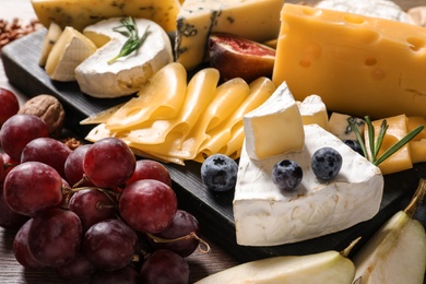 Photo of Composition with different delicious cheeses and fruits, closeup