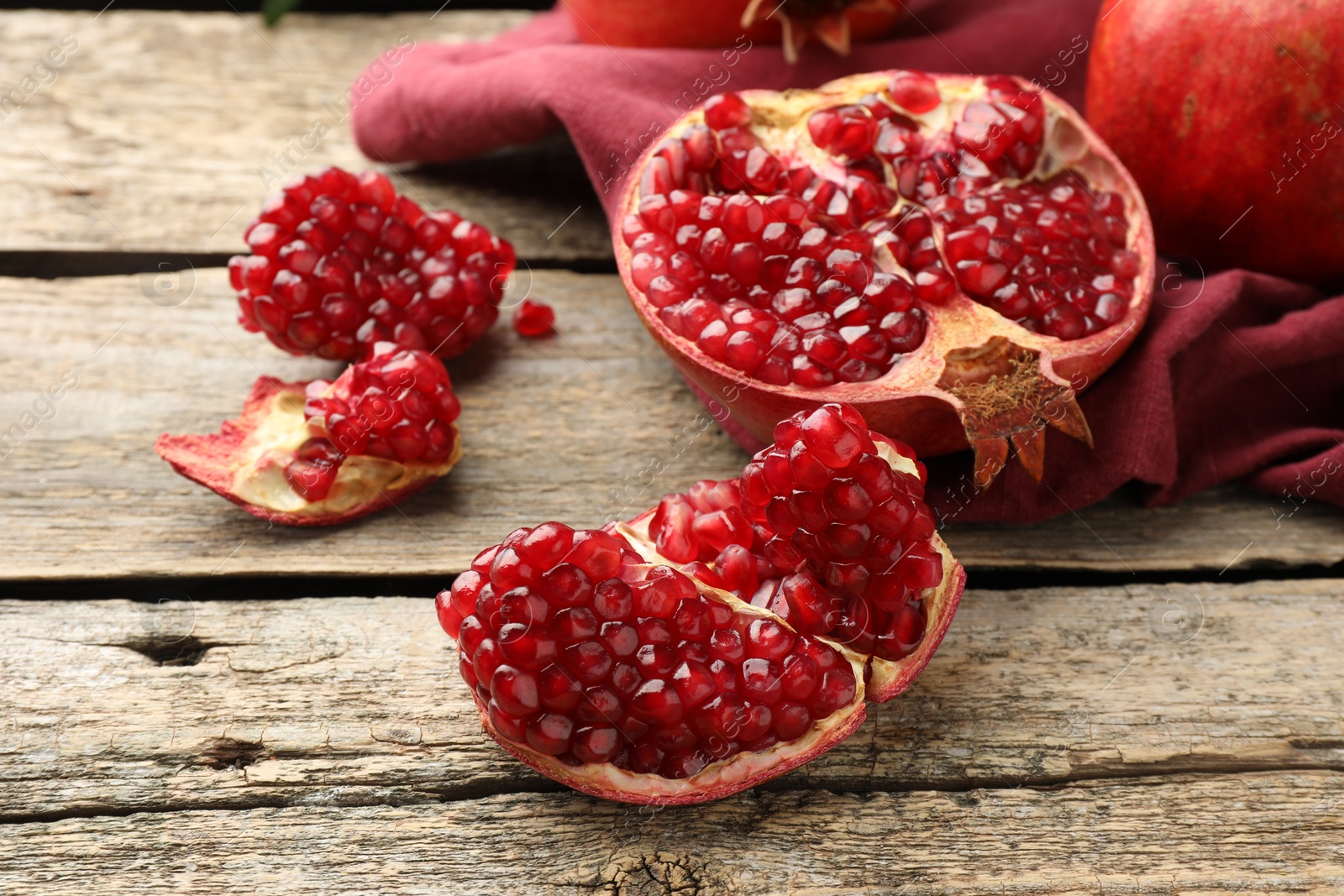 Photo of Cut fresh pomegranate on wooden table, closeup