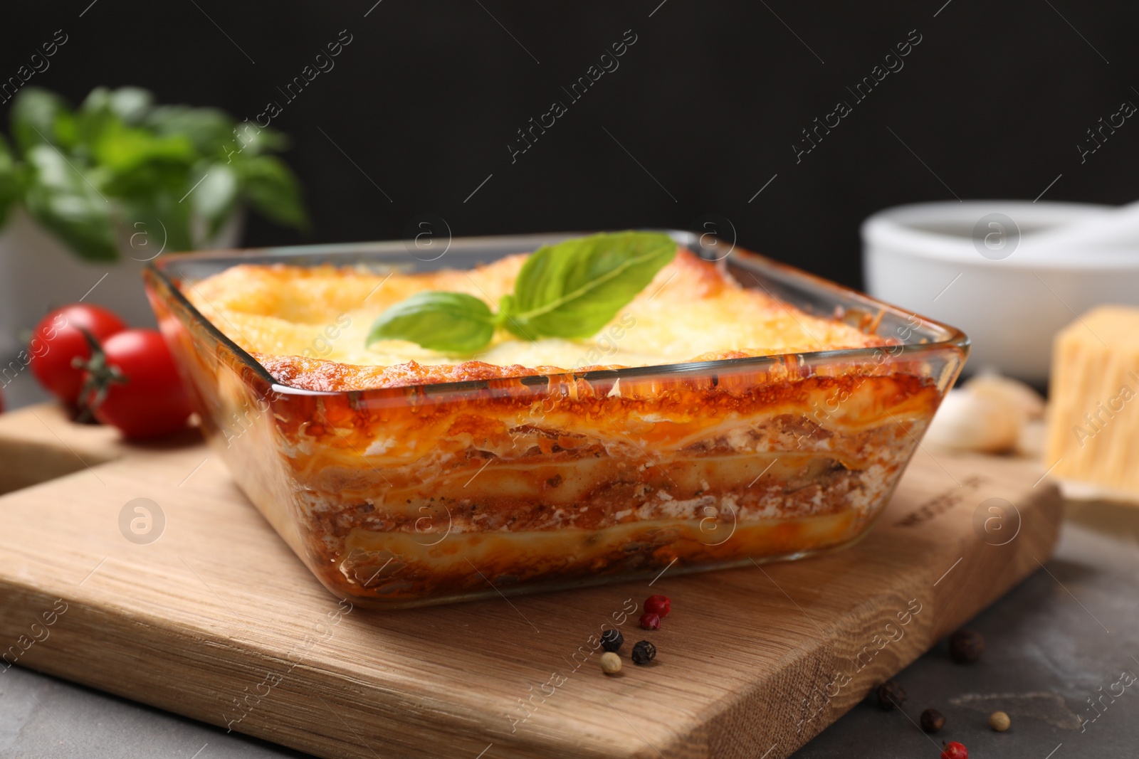 Photo of Tasty cooked lasagna in baking dish on grey table, closeup