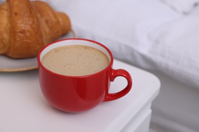 Morning coffee and croissant on white table, closeup. Space for text