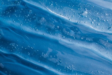 Photo of Texture of light blue shower gel as background, top view