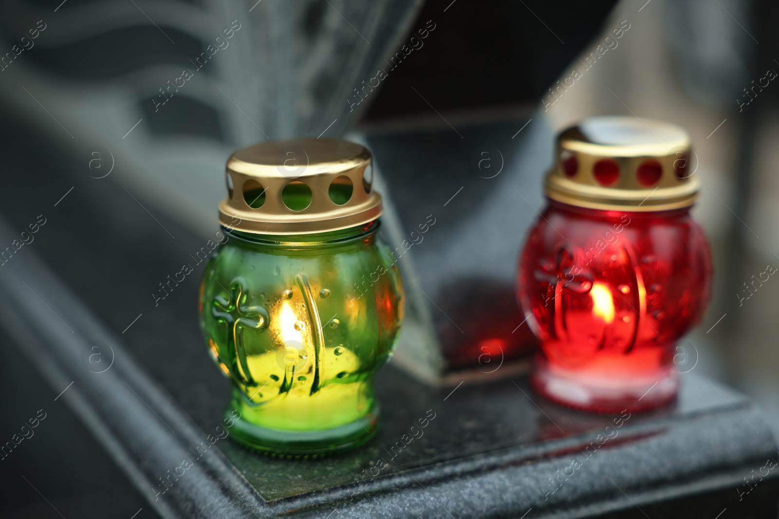 Photo of Grave lights on granite tombstone at cemetery, closeup