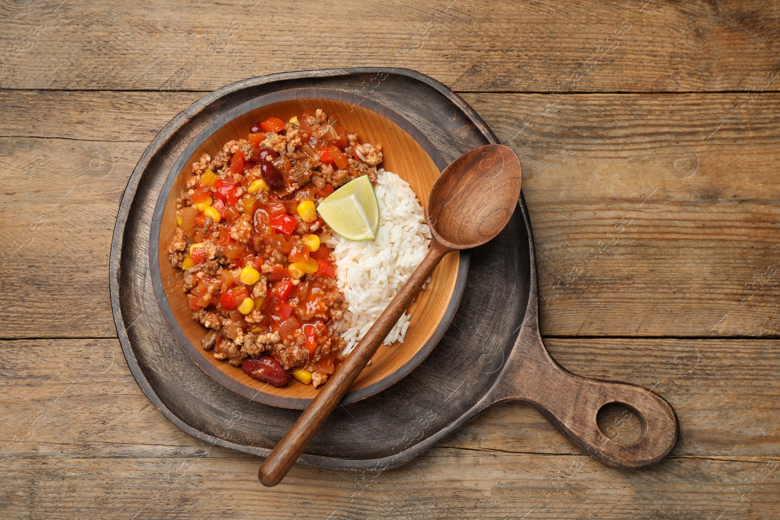 Photo of Plate of rice with chili con carne on wooden table, top view