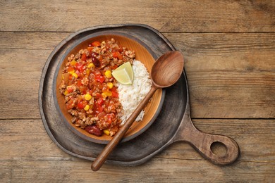 Plate of rice with chili con carne on wooden table, top view