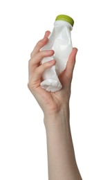 Photo of Woman holding crumpled plastic bottle on white background, closeup