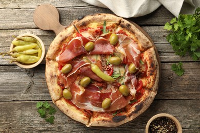 Photo of Tasty pizza and ingredients on wooden table, top view