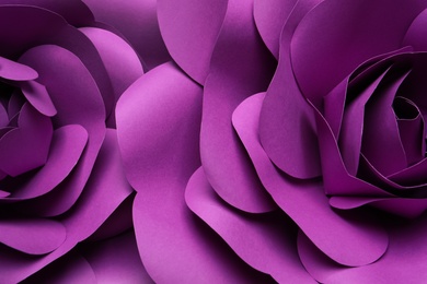 Beautiful purple flowers made of paper as background, top view