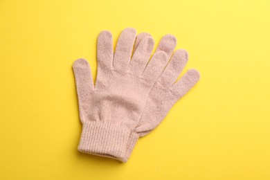 Photo of Pair of stylish woolen gloves on yellow background, flat lay