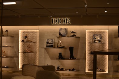 Photo of Paris, France - December 10, 2022: Dior store display with different shoes and bags