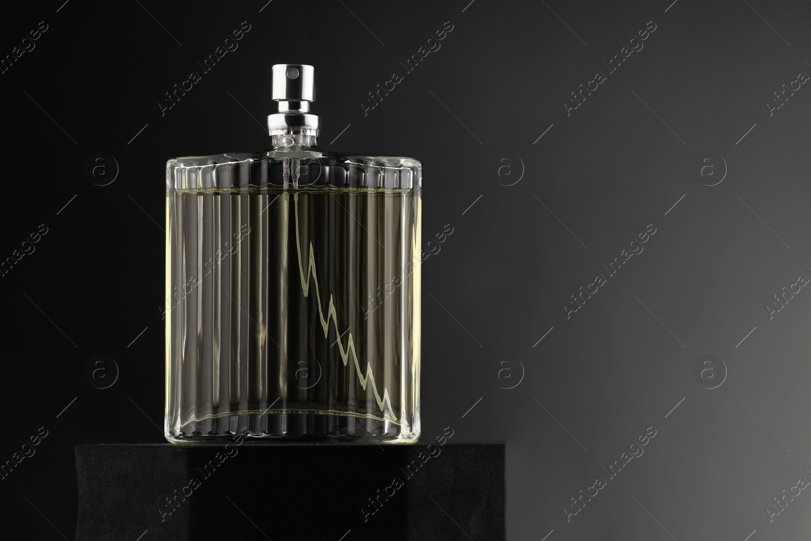 Photo of Luxury men`s perfume in bottle against grey background, space for text