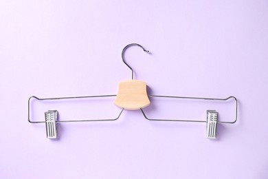 Photo of Hanger with clips on violet background, top view