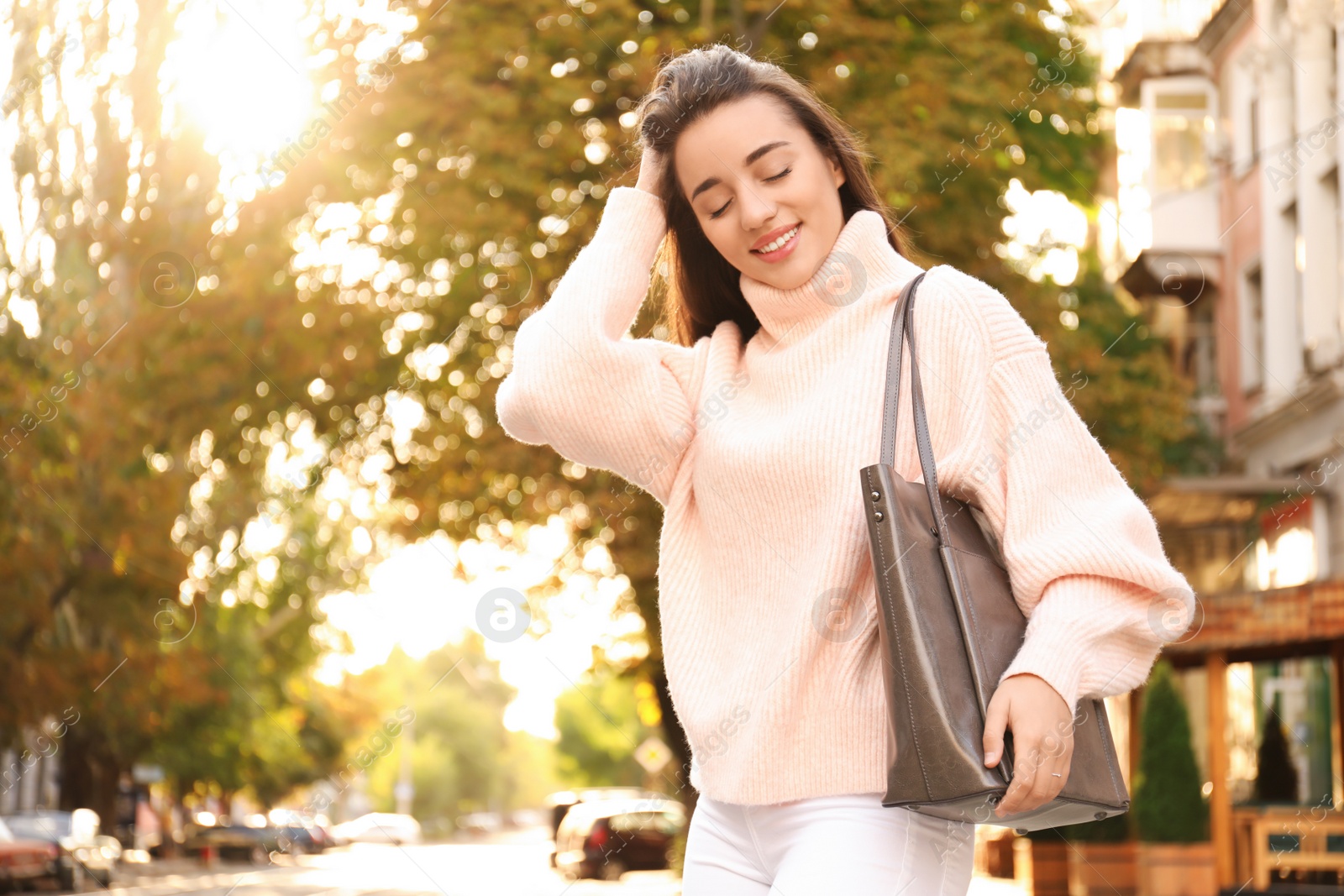 Photo of Young woman with stylish shopper bag outdoors