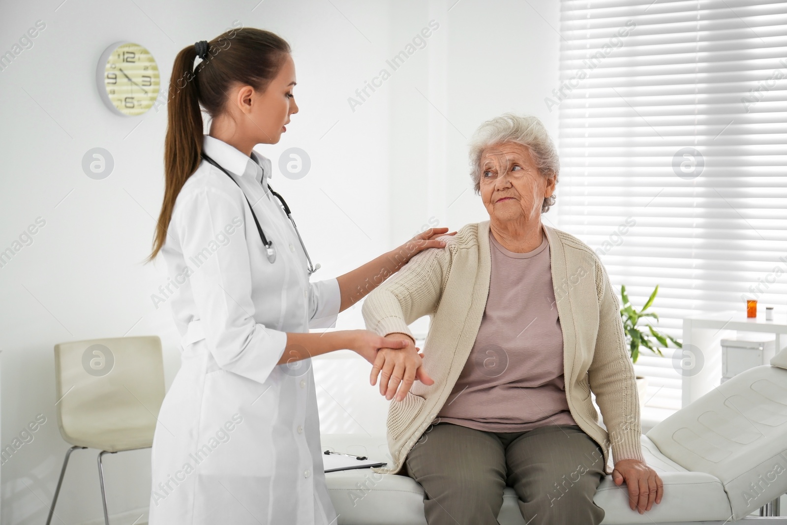 Photo of Doctor examining senior patient in modern office