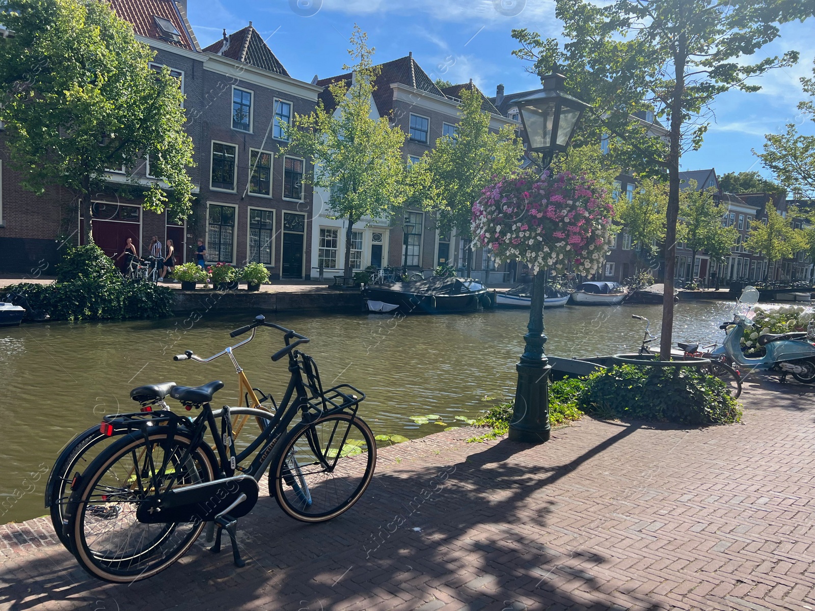 Photo of Leiden, Netherlands - August 03, 2022: View of city street with buildings along canal