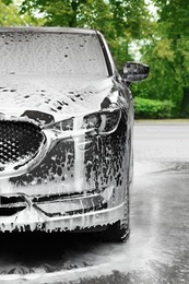 Auto with cleaning foam at car wash