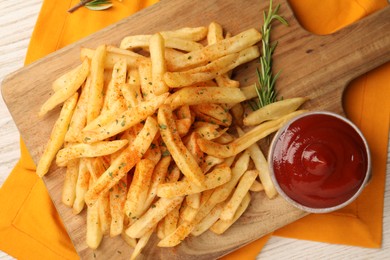 Delicious french fries served with sauce on white wooden table, flat lay