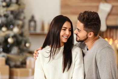 Image of Happy couple in living room decorated for Christmas