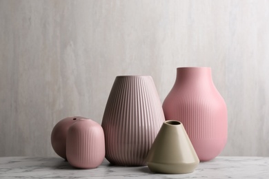 Stylish empty ceramic vases on white marble table