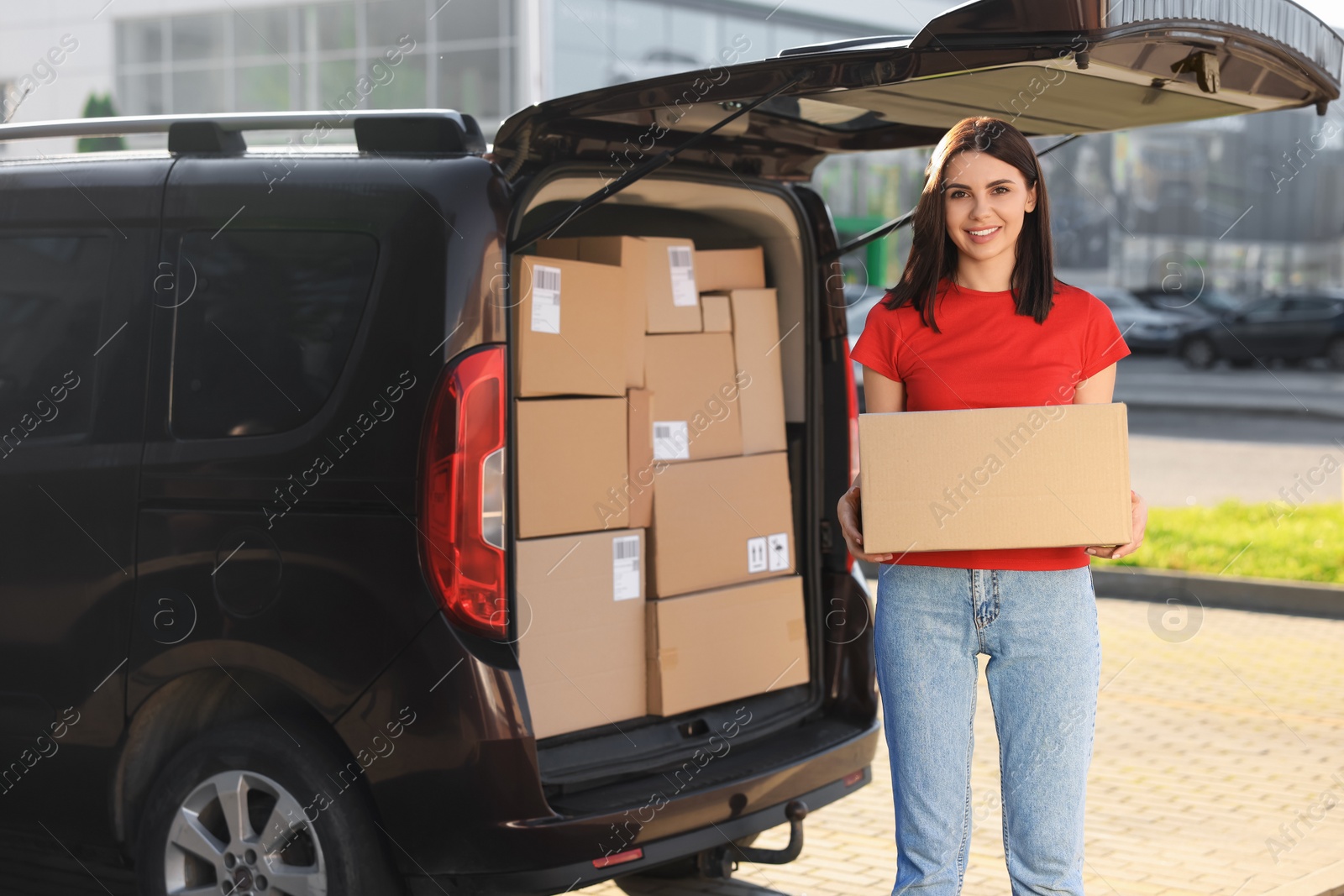 Photo of Courier with parcel near delivery van outdoors, space for text