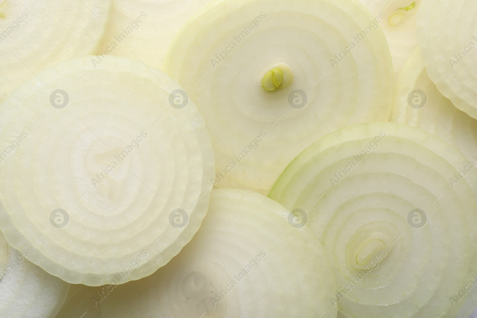 Photo of Slices of fresh ripe onion as background, top view