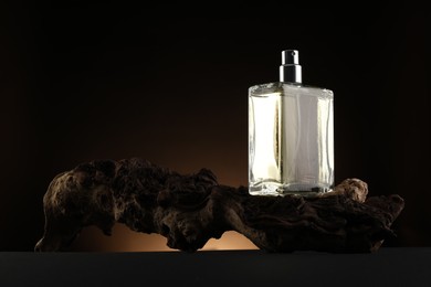 Photo of Luxury men`s perfume in bottle on table against dark background