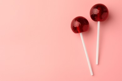 Tasty lollipops on pink background, flat lay. Space for text