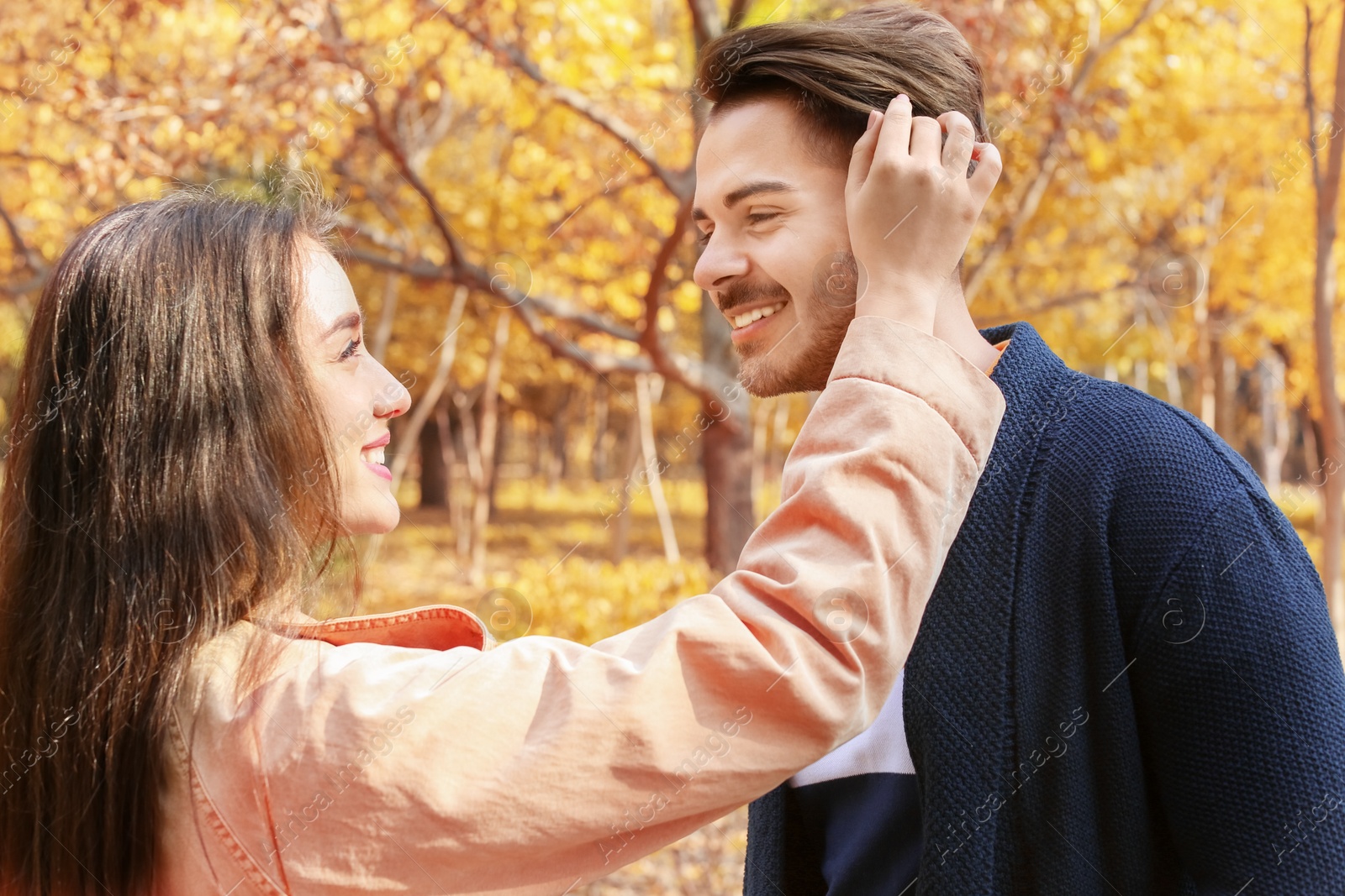 Photo of Young lovely couple spending time together in park. Autumn walk