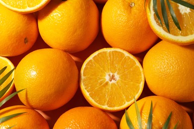 Photo of Tasty ripe fresh oranges and leaves as background, top view