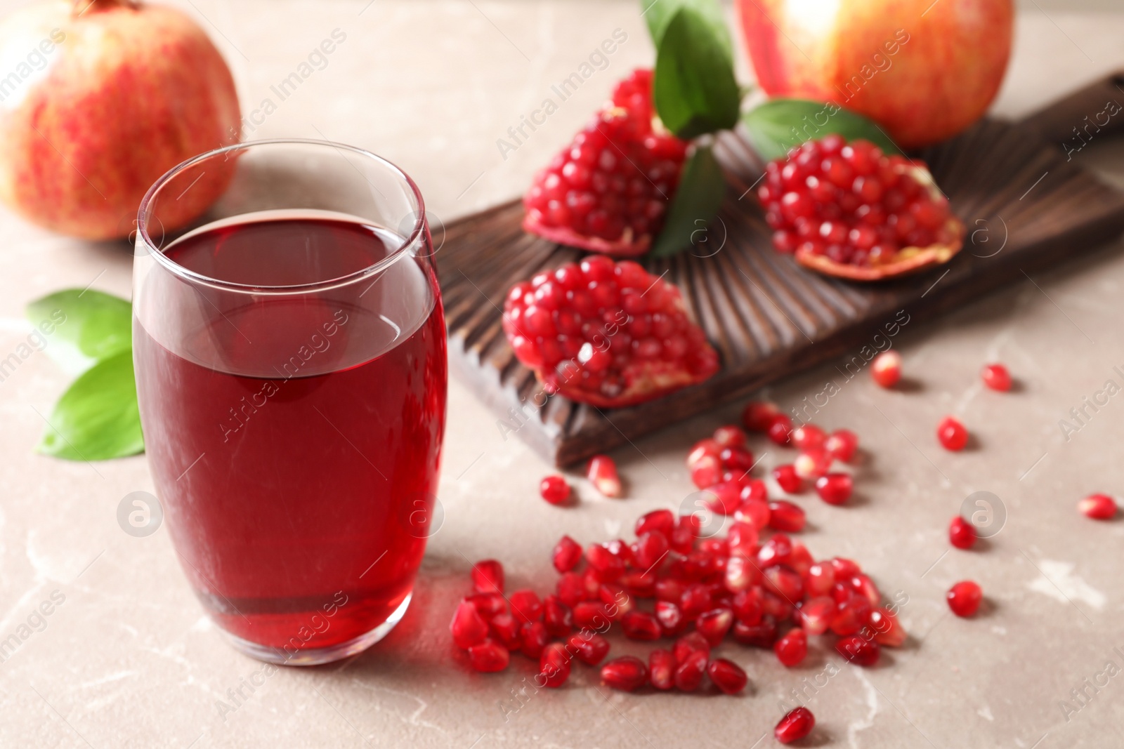 Photo of Composition with glass of fresh pomegranate juice on table