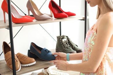 Photo of Young woman choosing shoes in store