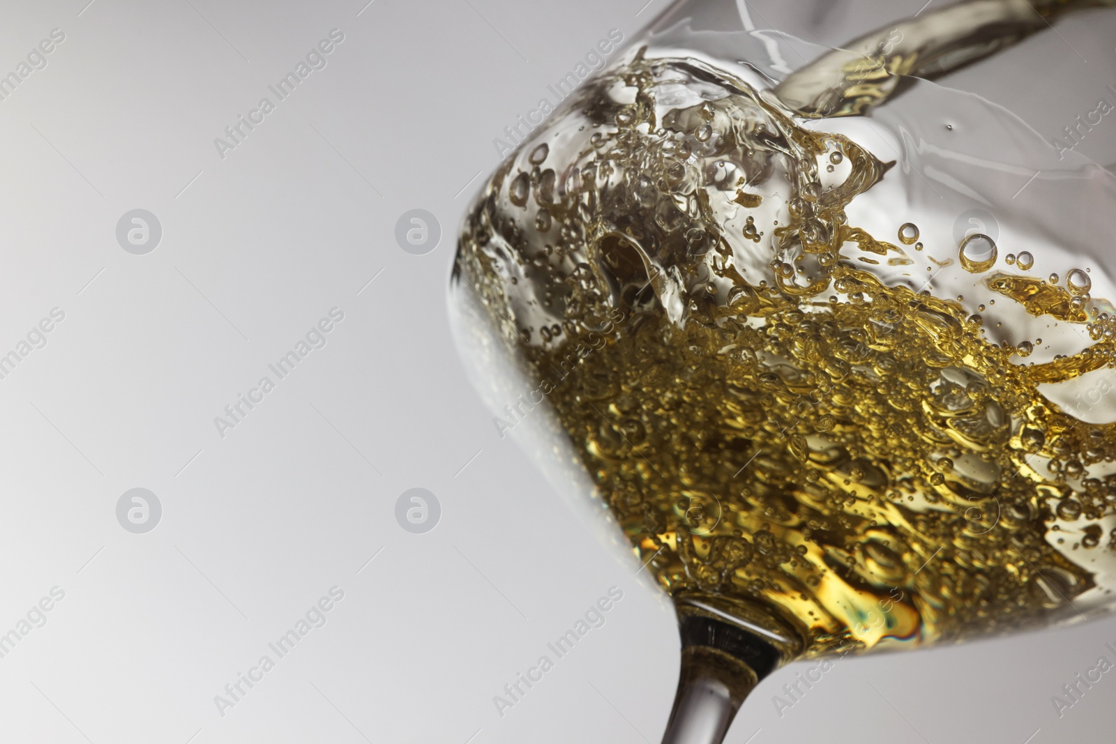 Photo of Tasty aromatic wine in glass on gray background, closeup. Space for text