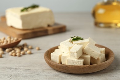 Photo of Pieces of delicious tofu with rosemary and soy on white table. Space for text