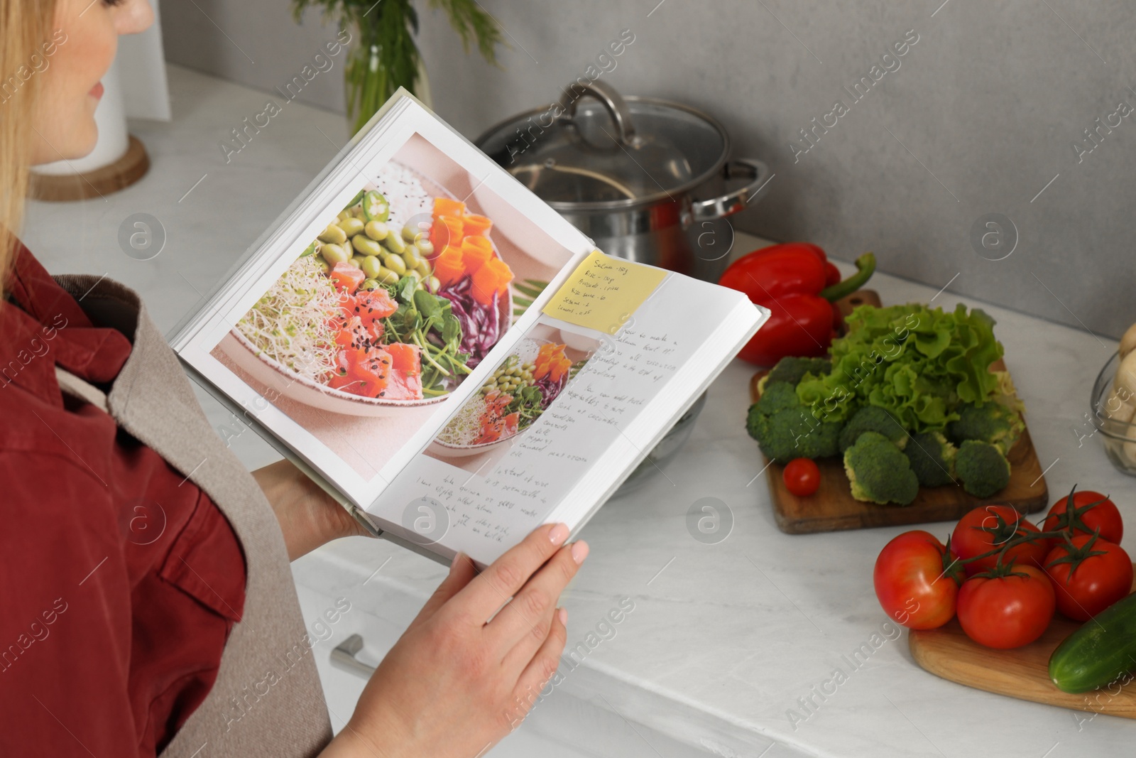 Photo of Woman with recipe book in kitchen, closeup. Space for text