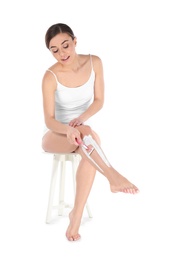 Photo of Beautiful young woman shaving leg on white background