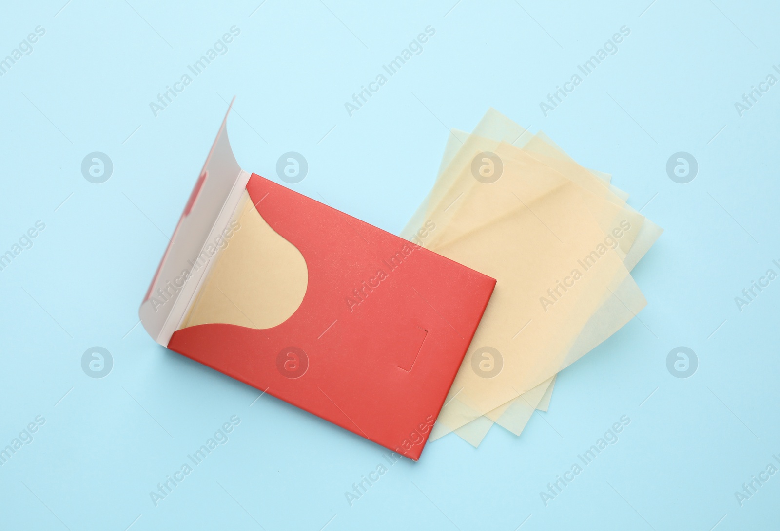 Photo of Package of facial oil blotting tissues on light blue background, above view. Mattifying wipes