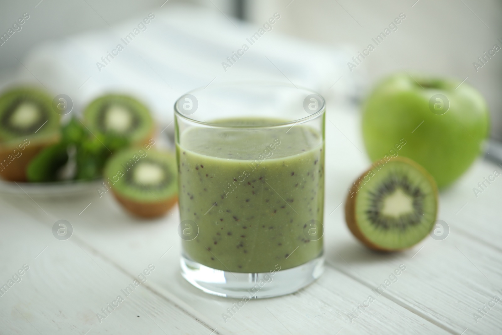 Photo of Delicious kiwi smoothie and fresh fruits on white wooden table