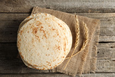 Photo of Tasty homemade tortillas and spikes on wooden table, top view